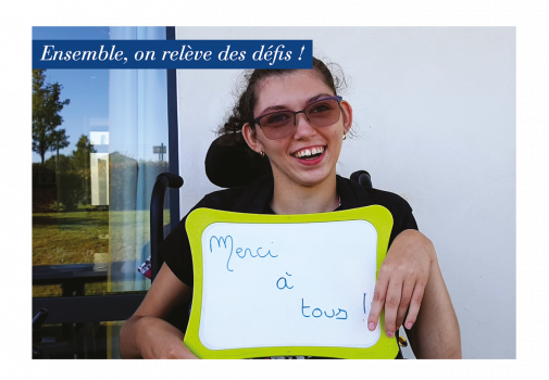 Jeune fille en situation de handicap tient une ardoise avec une inscription "Merci à tous"
