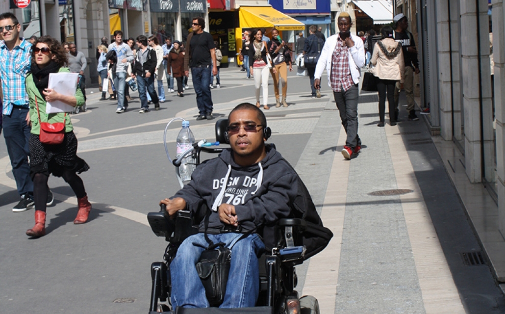 jeune homme en fauteuil dans les rues de la ville