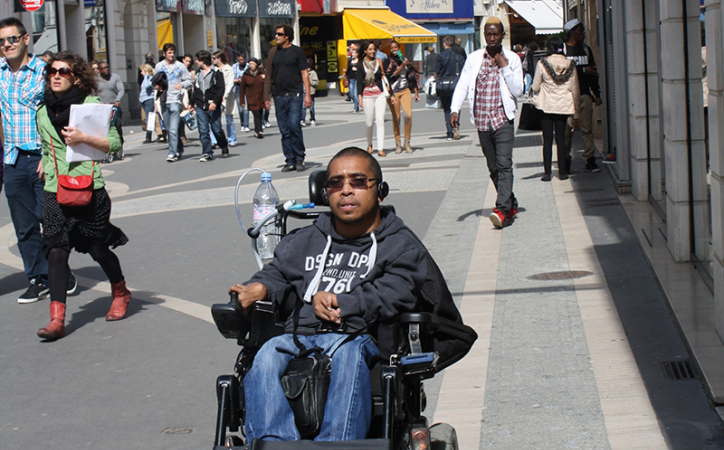 jeune homme en fauteuil dans les rues de la ville